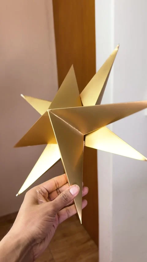 Hand Holding Metallic Gold 3D Christmas Star Decoration Stock Footage 341460265