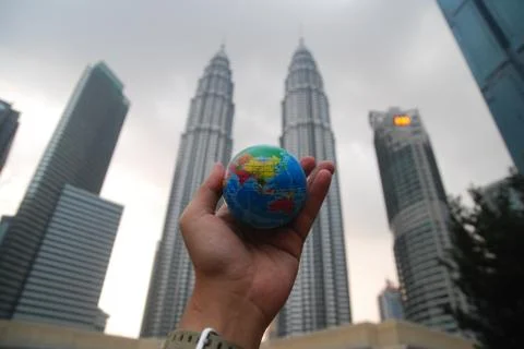 Hand holding a mini globe capture the Petronas twin tower Stock Photos