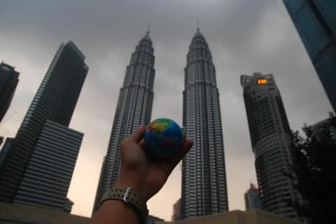 Hand holding a mini globe capture the Petronas twin tower Foto stock