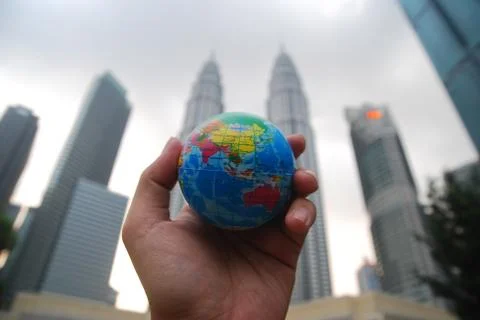Hand holding a mini globe capture the Petronas twin tower Stock Photos