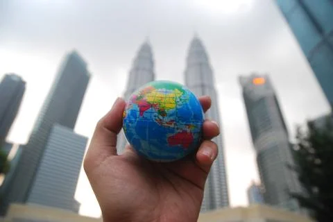 Hand holding a mini globe capture the Petronas twin tower Stock Photos