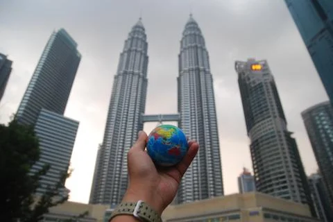 Hand holding a mini globe capture the Petronas twin tower Stock Photos
