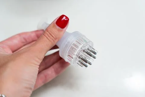 Hand holding a minoxidil applicator on white background Stock Photos