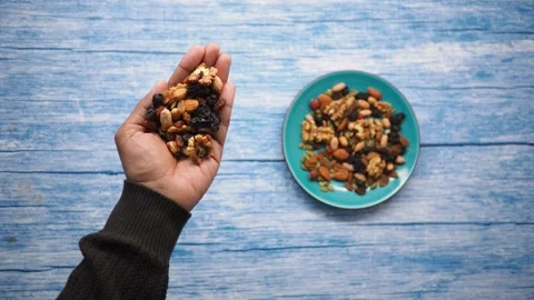 Hand holding mixed nuts and dried fruits Stock Footage 345016273