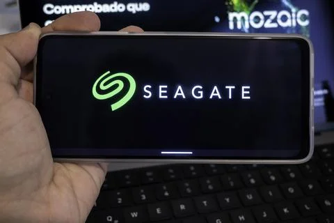 Hand holding mobile device displaying seagate brand logo Stock Photos