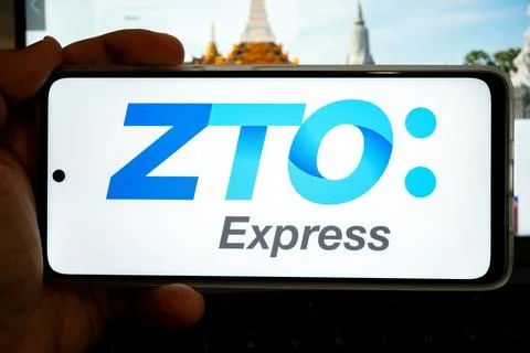 Hand holding mobile device displaying zto express logo Stock Photos