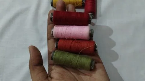 Hand holding multiple color thread roll Stock Photos