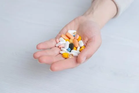Hand holding multiple pills, concept of medication overload and excessive d.. Stock Photos