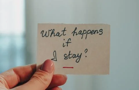 Hand holding note with question about staying, blurred background visible Stock Photos
