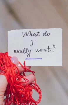 Hand holding note with question and red thread in blurred background Stock Photos
