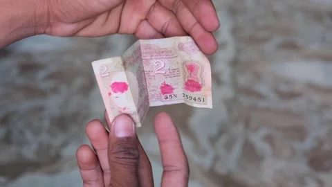 Hand holding an old 2 Rupee Indian banknote featuring Aryabhatta satellite Видео 330660992