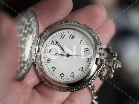 Hand holding old silver vintage pocket watch Stock Photos