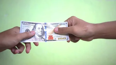 Hand holding a one hundred dollar bill against a green background Stock Footage 322109966