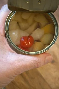 Hand holding open can with fruit salad, convenience and lifestyle concept, Copy  Foto stock