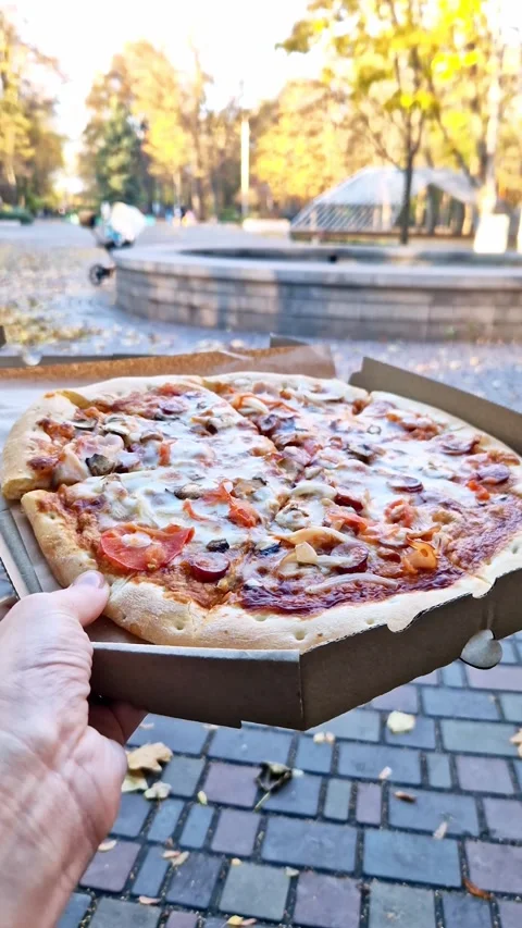 Hand Holding Open Pizza Box in Autumn Park POV Stock Footage 323547760