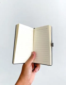 A hand holding an opened textbook Stock Photos