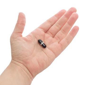 Hand holding or offering black capsule. Isolated on white background. Medicin Stock Photos