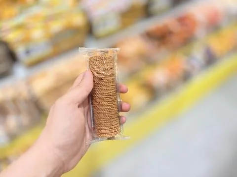 Hand Holding Pack of Round Crackers in Grocery Store Aisle Stock-Fotos