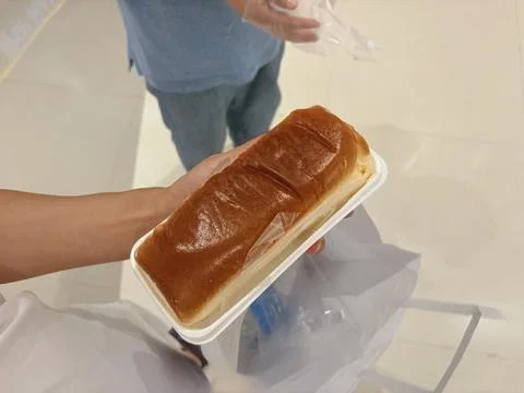 Hand Holding a Packaged Loaf of Bread Fotos de archivo