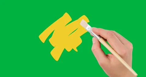 Hand holding a paint brush over yellow paint stain against copy space on Stock Footage 318379853