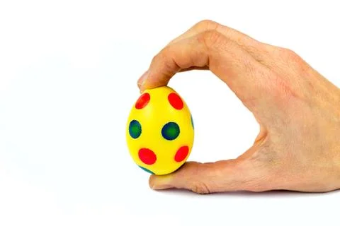 Hand holding painted yellow easter egg with dots Stock Photos
