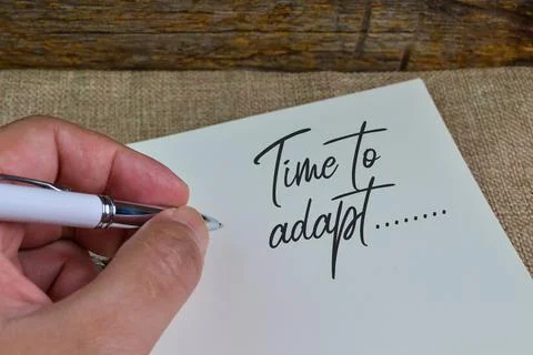 Hand holding pan and write TIME TO ADAPT" Foto stock