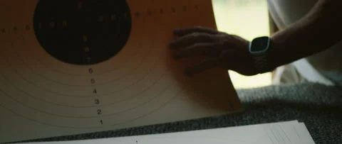 Hand holding paper target sheet at shooting range, man sets shooting target Video stock 309574068