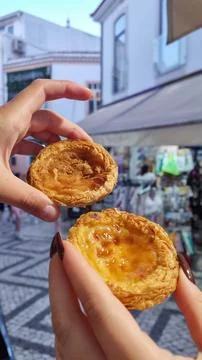 Hand holding Pasteis de Belem, Portuguese pastel de Nata Custard Tarts. 库存照片
