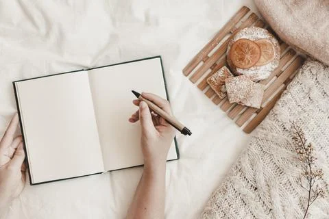 Hand holding pen with opened notebook bed. High quality photo Stock Photos