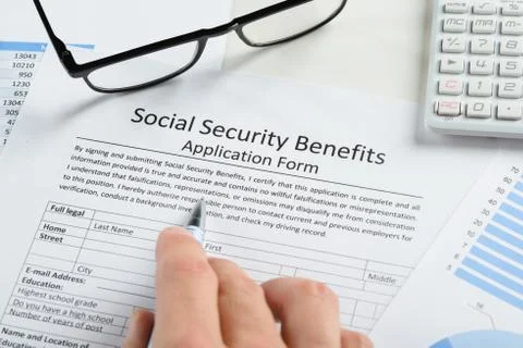Hand Holding Pen Over Social Security Benefits Form Stock Photos