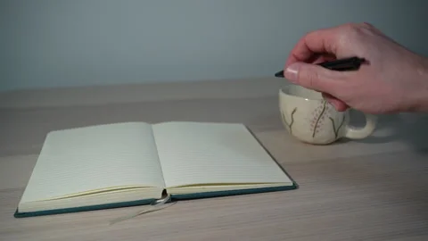 Hand holding pen, preparing to write in notebook Video stock 327350263