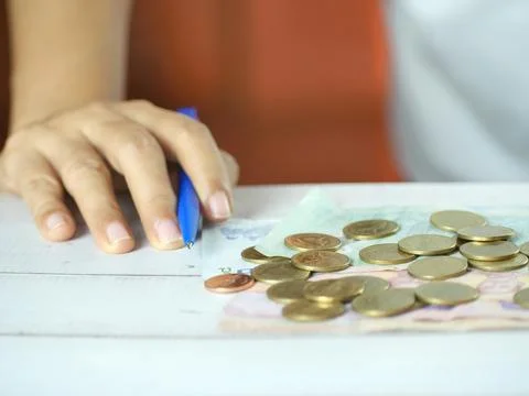 Hand holding pen to take notes and count money on the desk. Financial busin.. Stock Photos