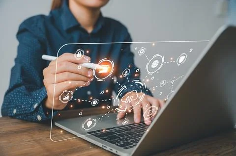 Hand holding pen touching computer infographics and technology icons relate.. Stock Photos