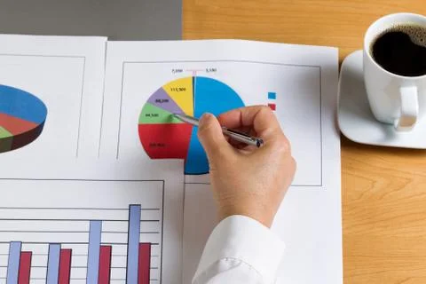 Hand holding pen while looking at data financial pie chart Stock Photos