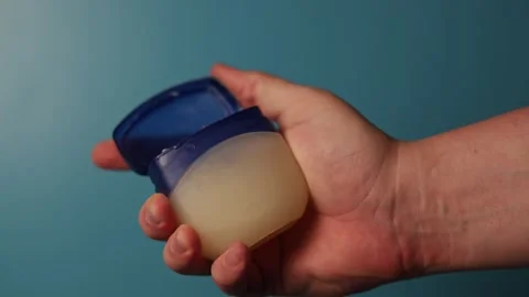 Hand holding petroleum jelly jar, opening and closing the lid Stock Footage 340268566