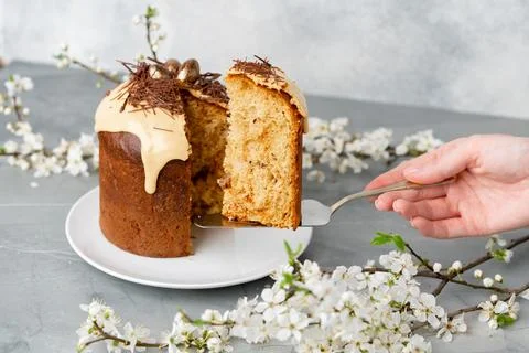 Hand holding piece of Easter cake on dessert spatula Stock Photos