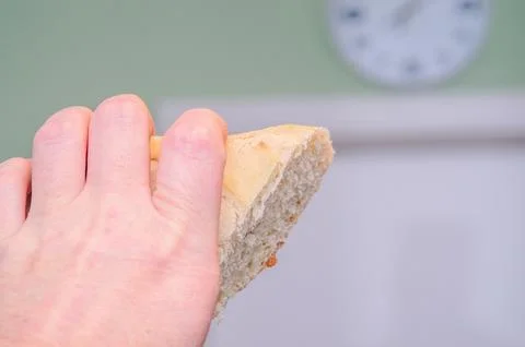 Hand holding a piece of fresh bread, ready to be eaten, close-up shot Stock Photos