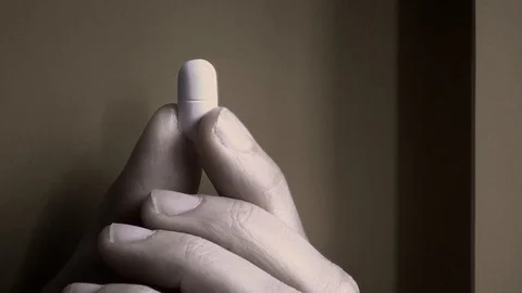 A hand holding a pill Stock Footage 104553750
