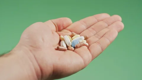 Hand holding pills Stock Footage 99750431