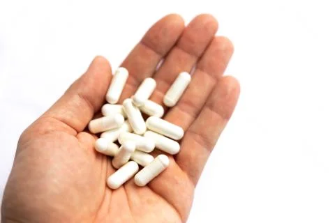Hand holding pills isolated on white background Stock Photos