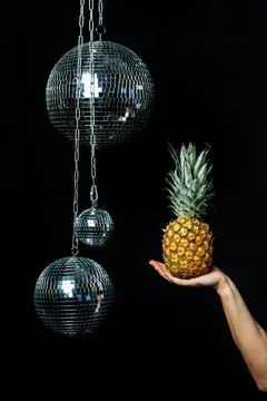 Hand holding a pineapple. Creative layout made of pineapple. Mirrored disco Photos