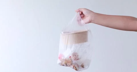 Hand holding plastic bag filled with food waste and used packaging, plastic.. Stock Footage 345647034