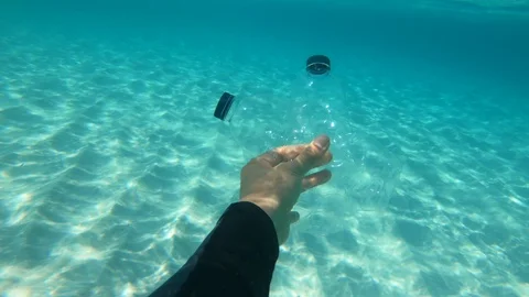 Hand holding plastic bottle trash in the ocean. Stock Footage 110744228