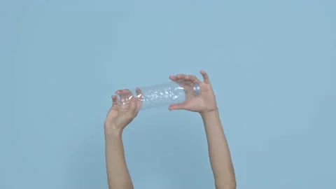 Hand holding plastic bottles ready to recycle on blue background. waste manag Stock Footage 149813387