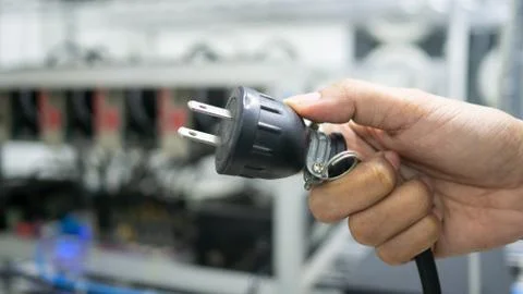 Hand holding plug have computer monitor in  the back, Concept Unplug bitcoin Stock Photos