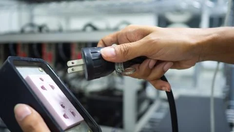 Hand holding plug have computer monitor in  the back, Concept Unplug bitcoin Stock Photos