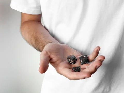 Hand holding polyhedral dice for tabletop gaming and role-playing games Stock Photos