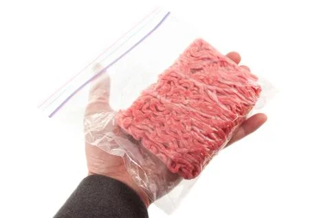 Hand holding a portion of beef ground beef in plastic bag Foto stock
