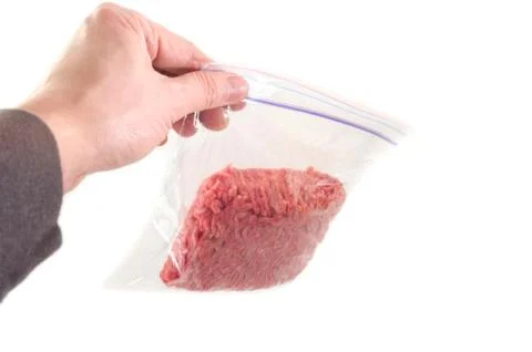 Hand holding a portion of beef ground beef in plastic bag Stock Photos
