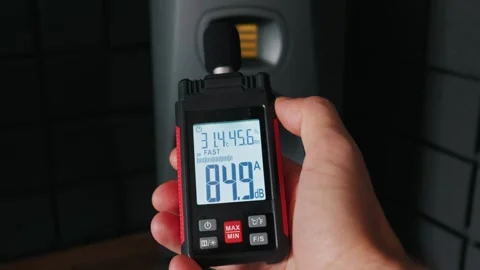 Hand Holding Professional Sound Level Meter to Measure Decibels in Studio Stock Footage 338100387
